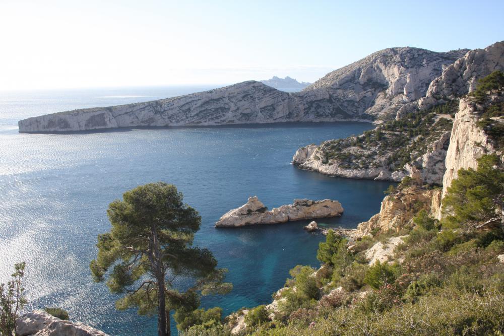 Cap Sugiton : la falaise des Calanques des Pierres Tombées tombant à droite, le Torpilleur, le Cap Sugiton, l'Île de Riou dévoilée dans la fenêtre du Col du Renard de Morgiou