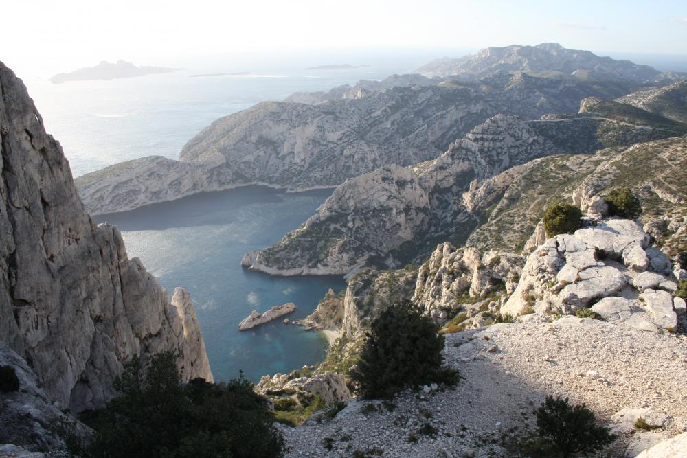 Calanques des Pierres Tombées : vue plongeante depuis le Col de la Candelle : les Calanques des Pierres Tombées, le Torpilleur, le Cap Sugiton puis en diagonale la crête de l'Aiguille de Sugiton puis du Crêt de St-Michel