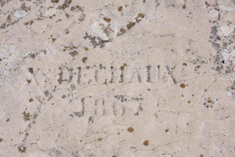 Grotte Dechaux : "X DECHAUX 1867" gravé sur la grande dalle rocheuse face aux ruines de l'ancienne vigie du Sommet de Marseilleveyre