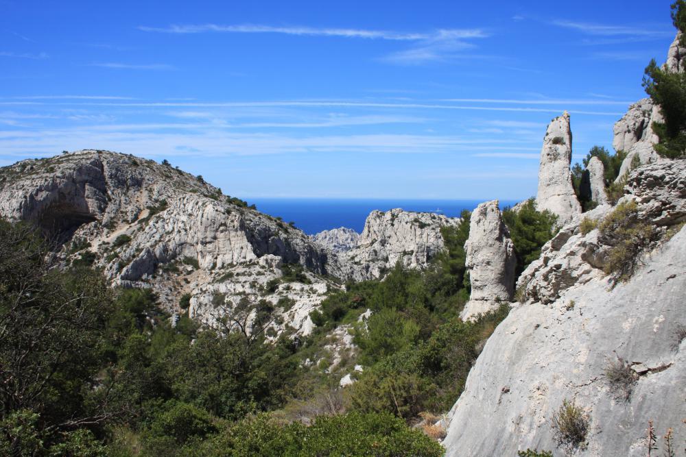 Baume Supérieure de la Mounine : à gauche la percée bien visible de la Baume Supérieure de la Mounine, à l'arrière du Rocher de St-Michel